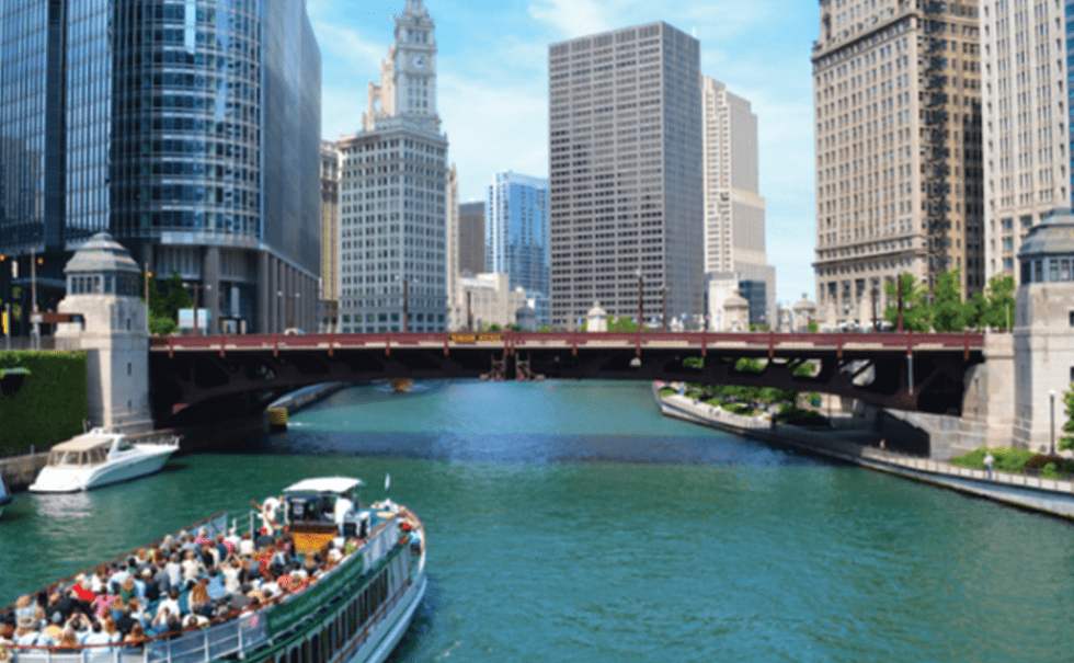 Image of the Chicago river with bridge and a tour boat